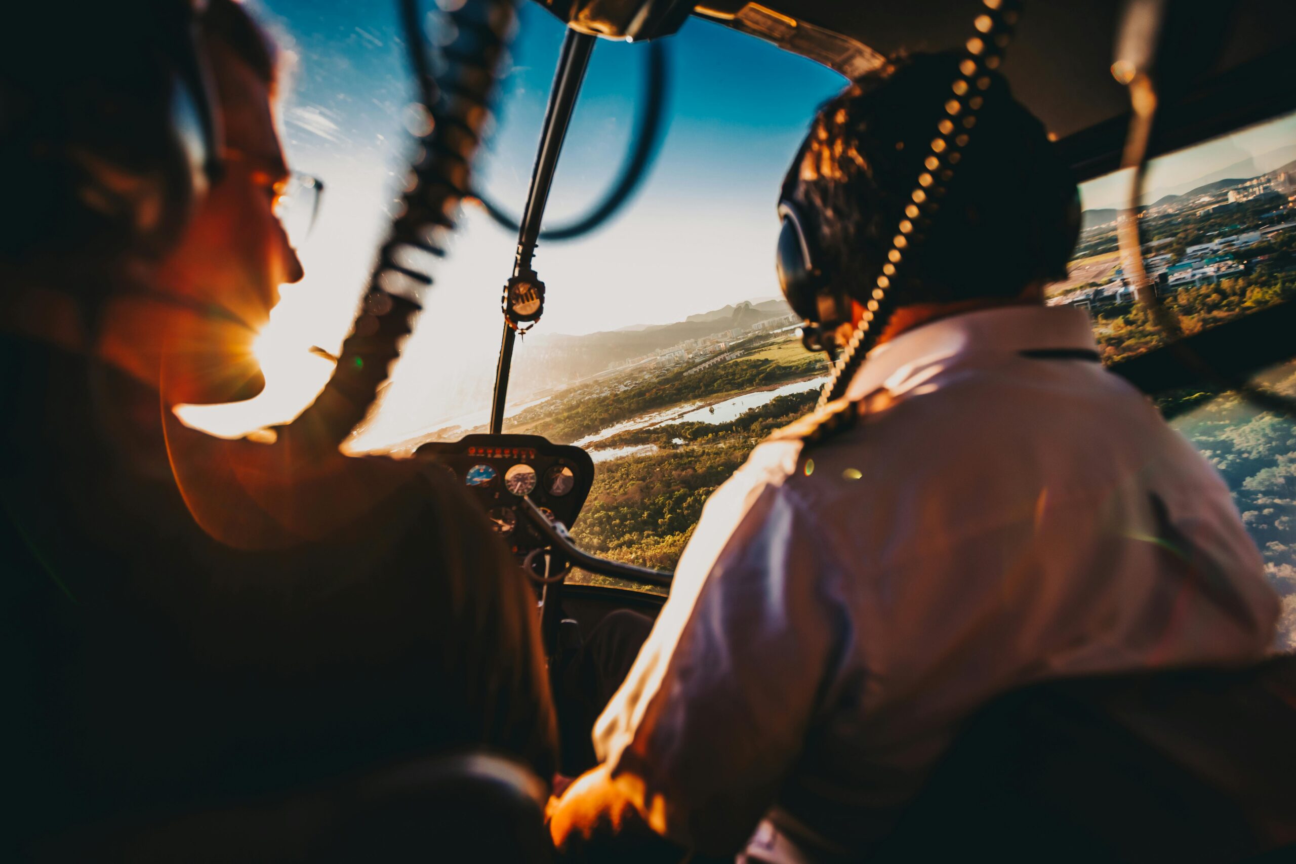 Two pilots navigate a helicopter over Rio de Janeiro during a stunning sunset, capturing the aerial adventure.